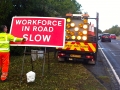 Workforce in Road Slow sign Implementation with Light Arrow Van.